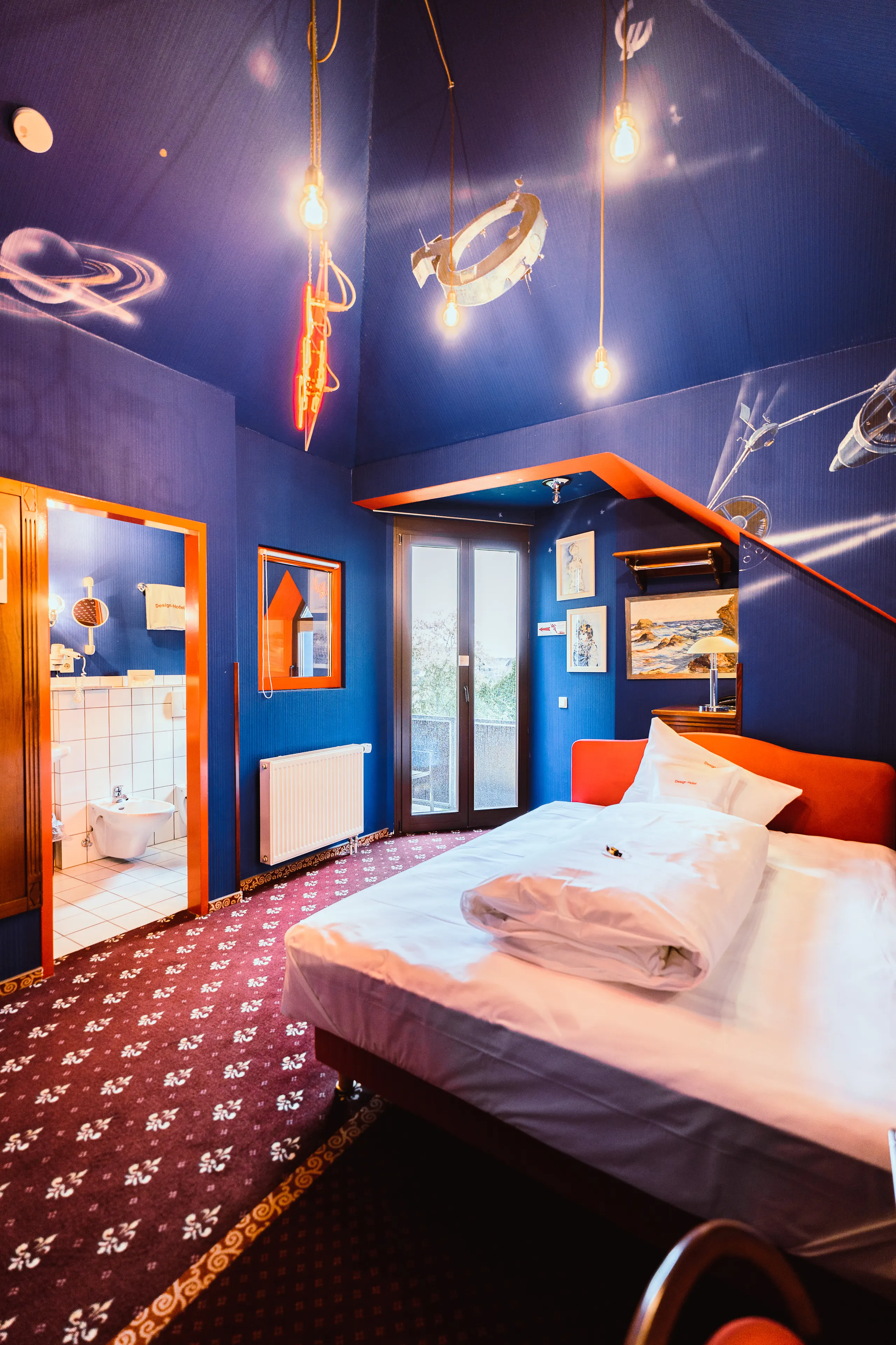 View of the bed with the balcony in the background - “Galactic Women” themed room